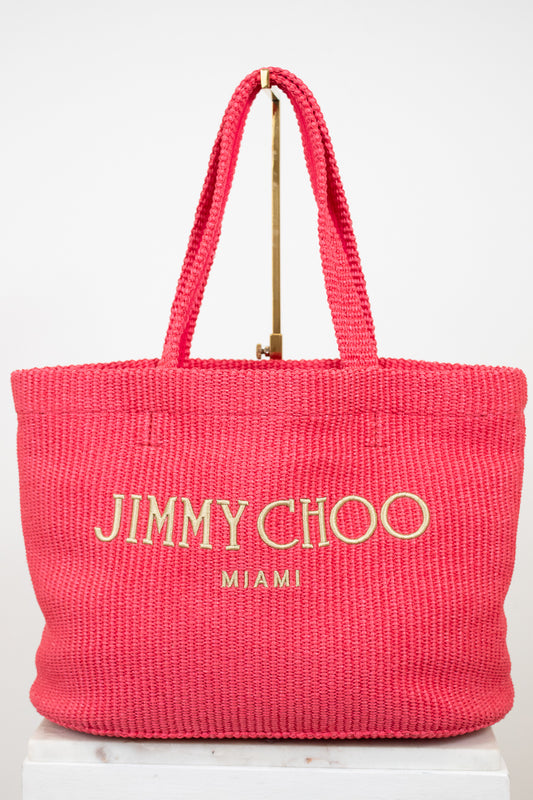 Pink tote bag with 'Jimmy Choo Miami' text on a white background