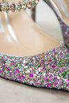Close-up of a glittery shoe with colorful rhinestones on a white background