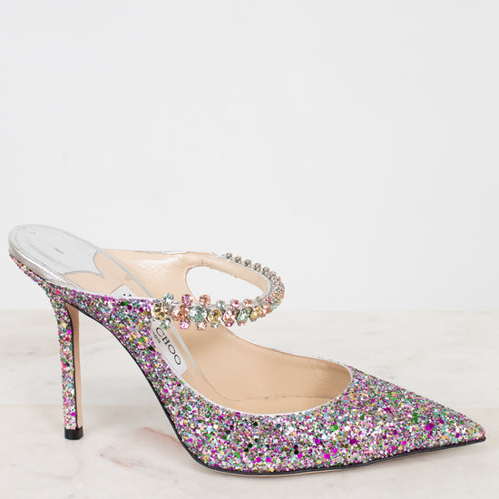 Sparkly high-heeled shoe with multicolor embellishments on a light background.