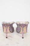 Multicolored glitter high-heeled shoes on a light background