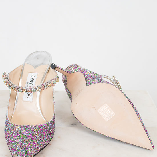 Pair of glittery high-heeled shoes on a white background