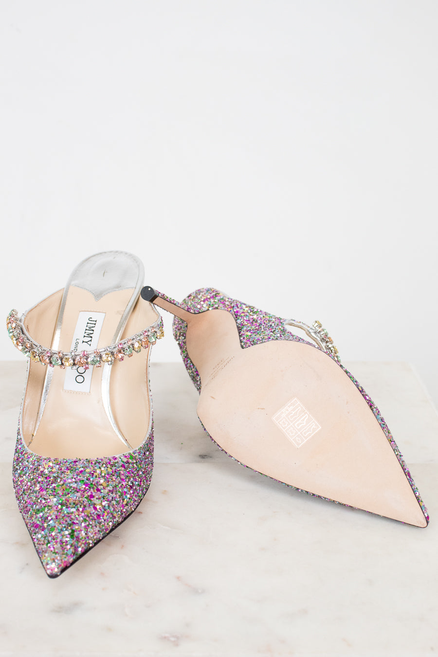 Pair of glittery high-heeled shoes on a white background
