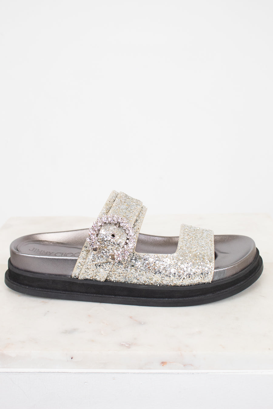 Silver sandal with rhinestone embellishments on a white background