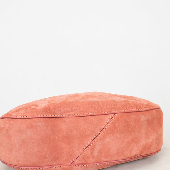 Pink suede bag on a light marble surface
