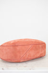 Pink suede bag on a light marble surface