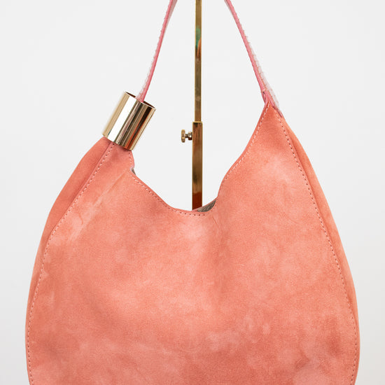 Pink handbag with gold accents on a white background