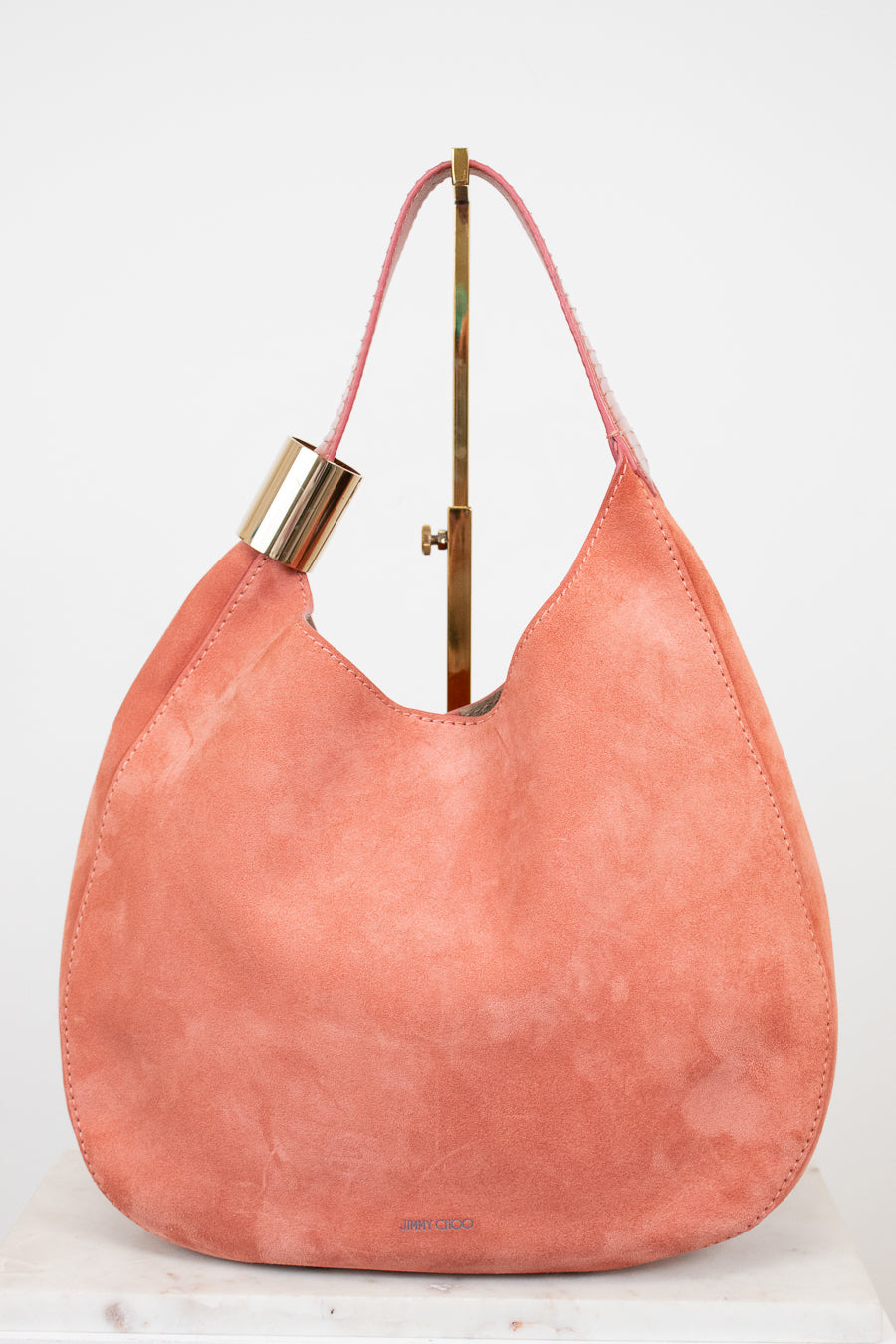 Pink handbag with gold accents on a white background