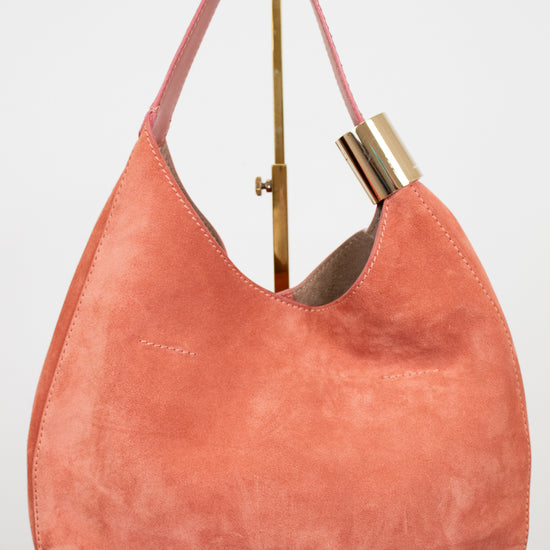 Pink handbag with gold accents on a white background