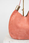 Pink handbag with gold handle on a white background