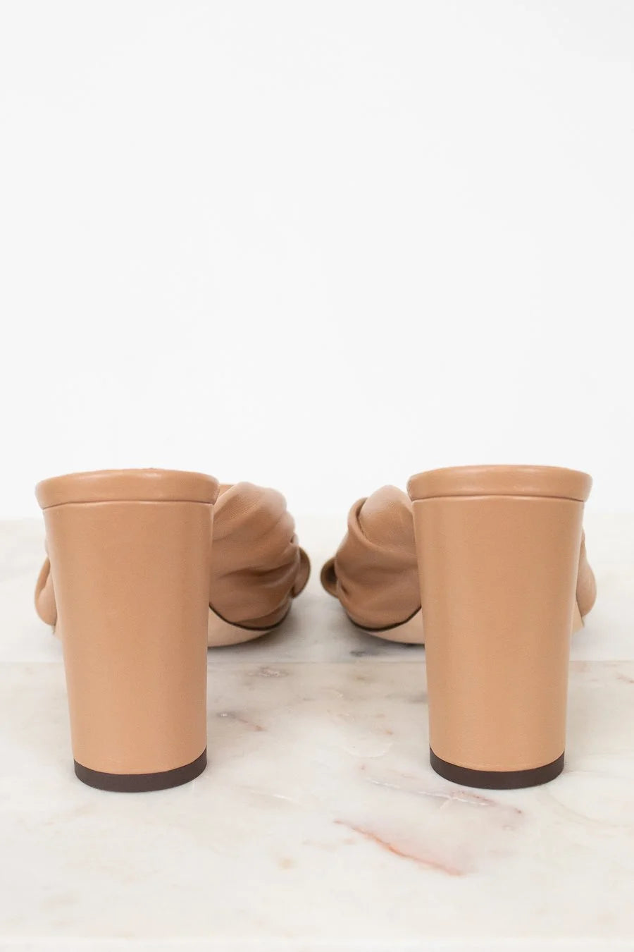 Tan high-heeled shoes on a white background