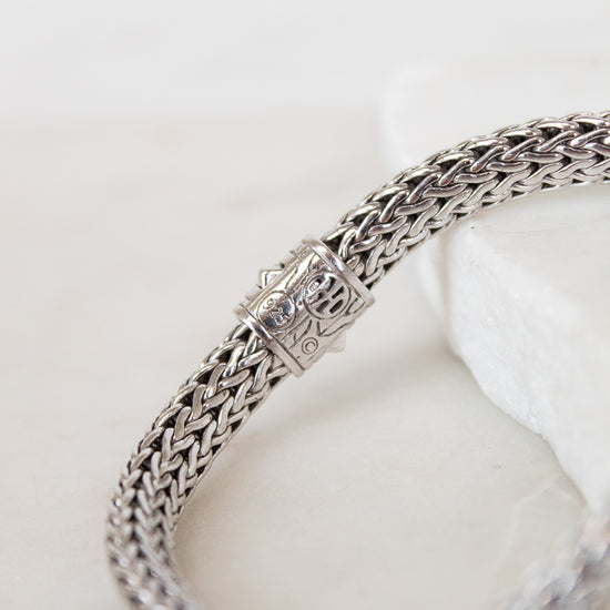 Silver braided bracelet on a white background