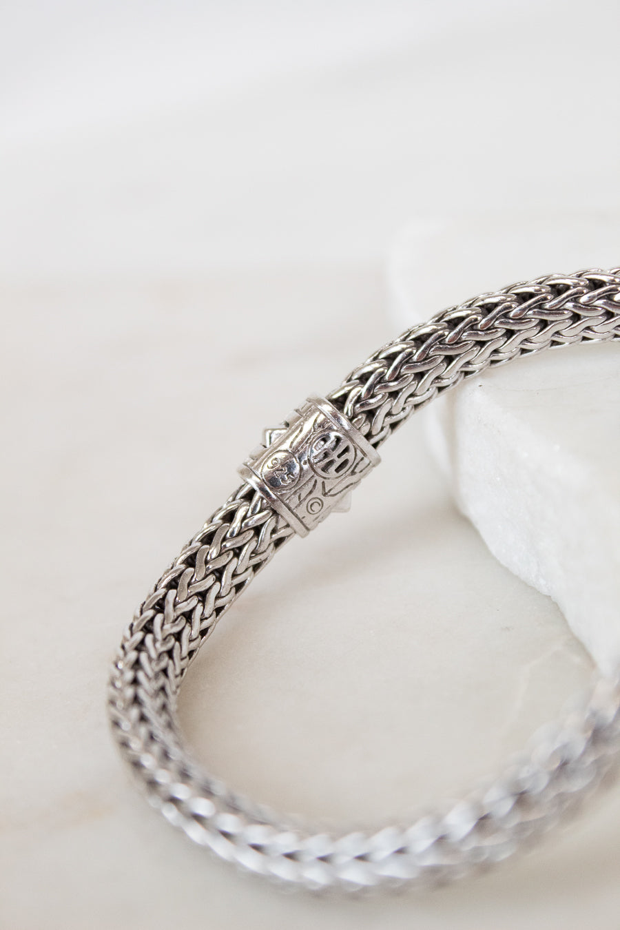 Silver braided bracelet on a white background