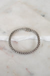 Silver chain bracelet on a marble surface