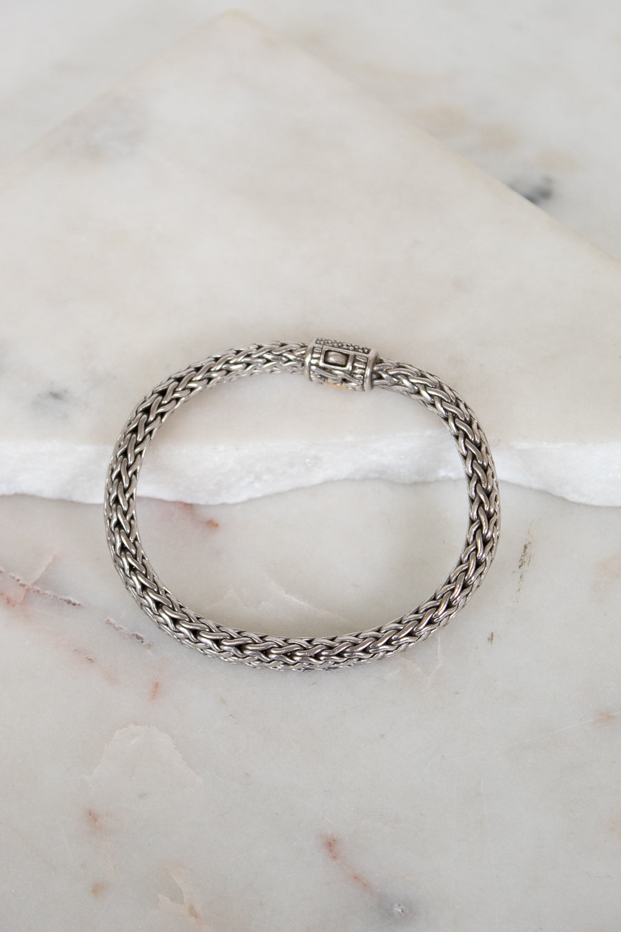 Silver chain bracelet on a marble surface