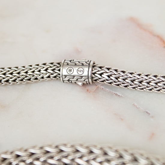 Close-up of a silver chain necklace on a marble surface