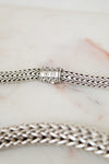Close-up of a silver chain necklace on a marble surface