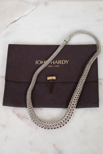 Silver chain necklace on a John Hardy pouch with a marble background