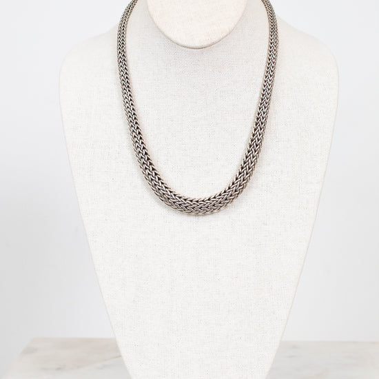 Silver chain necklace on a mannequin bust against a white background