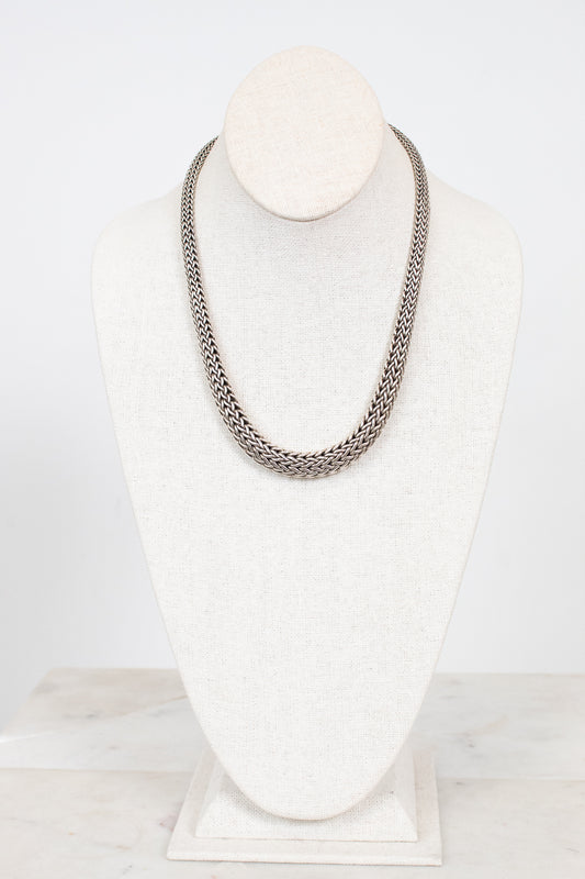 Silver chain necklace on a mannequin bust against a white background