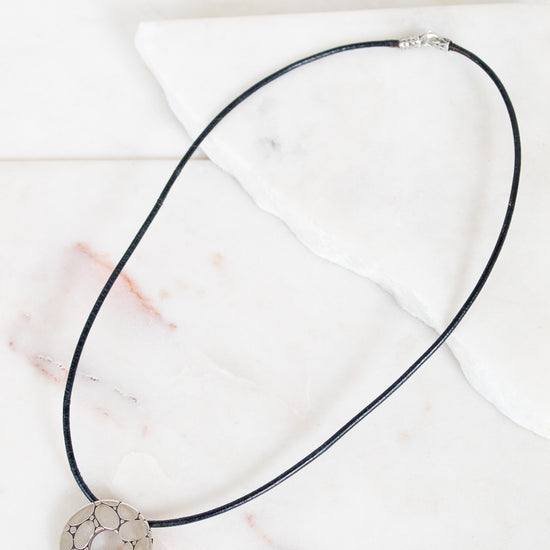 Necklace with a decorative pendant on a marble surface