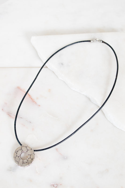 Necklace with a decorative pendant on a marble surface