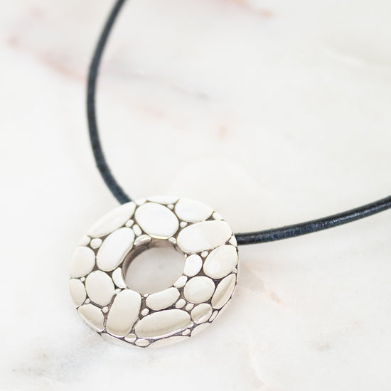 Necklace with a silver pendant on a light background
