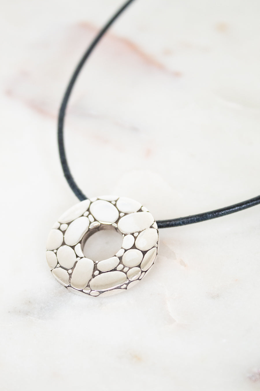 Necklace with a silver pendant on a light background