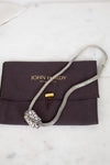 Silver necklace on a John Hardy branded pouch with a white background