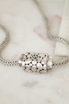 Silver necklace with a detailed pendant on a marble surface