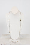 Long necklace with gold and silver beads on a mannequin head against a white background