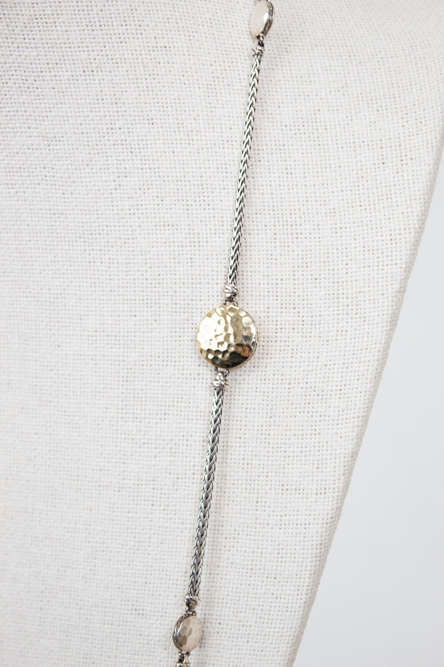 Silver beaded necklace on a mannequin with a white background