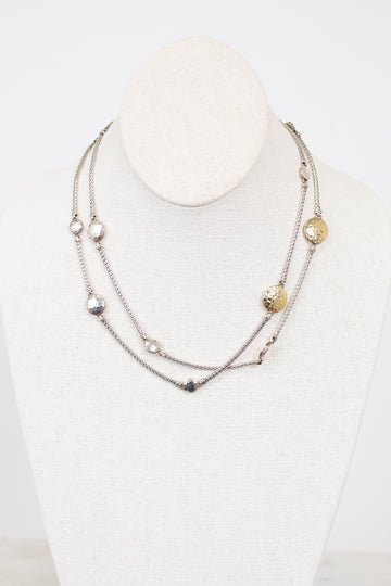 Multistrand necklace with various beads on a mannequin against a white background