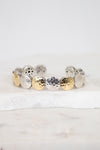 Bracelet with round, textured design in gold and silver on a white background