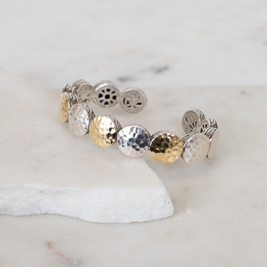 Bracelet with round, textured design on a marble surface