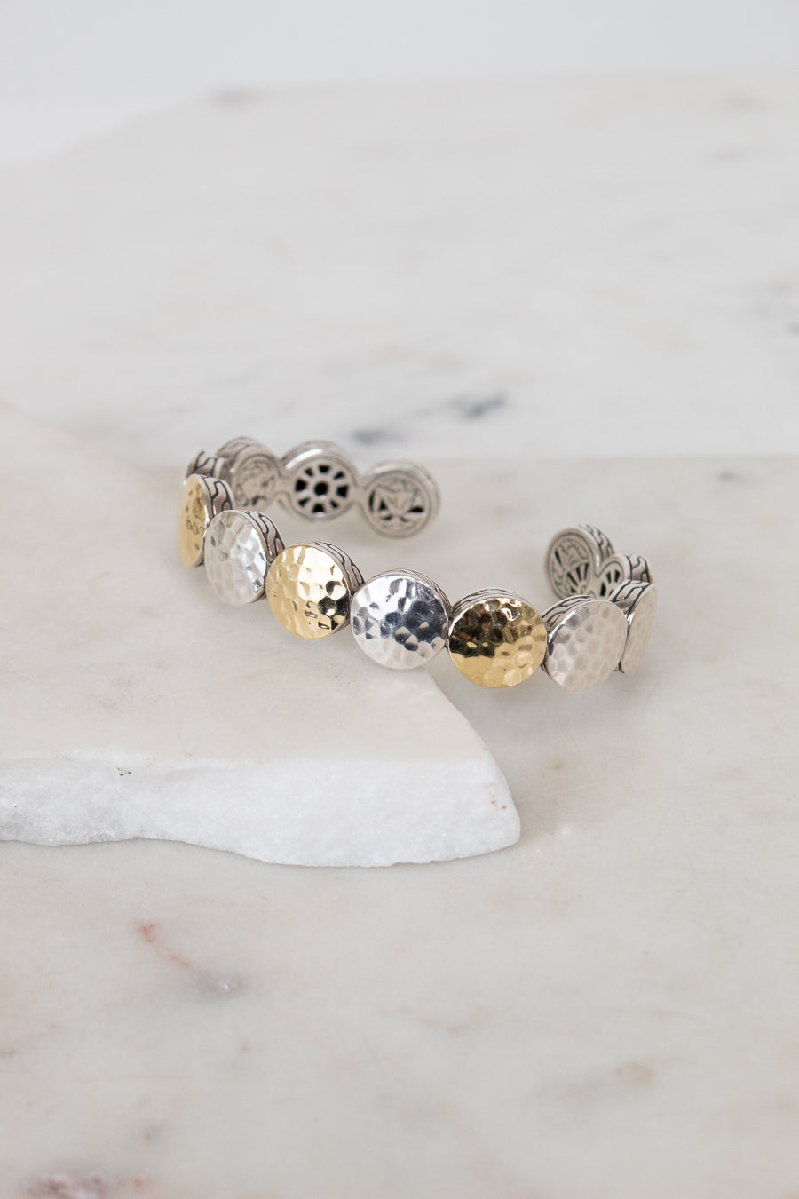 Bracelet with round, textured design on a marble surface