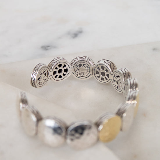 Silver bracelet with decorative elements on a marble surface
