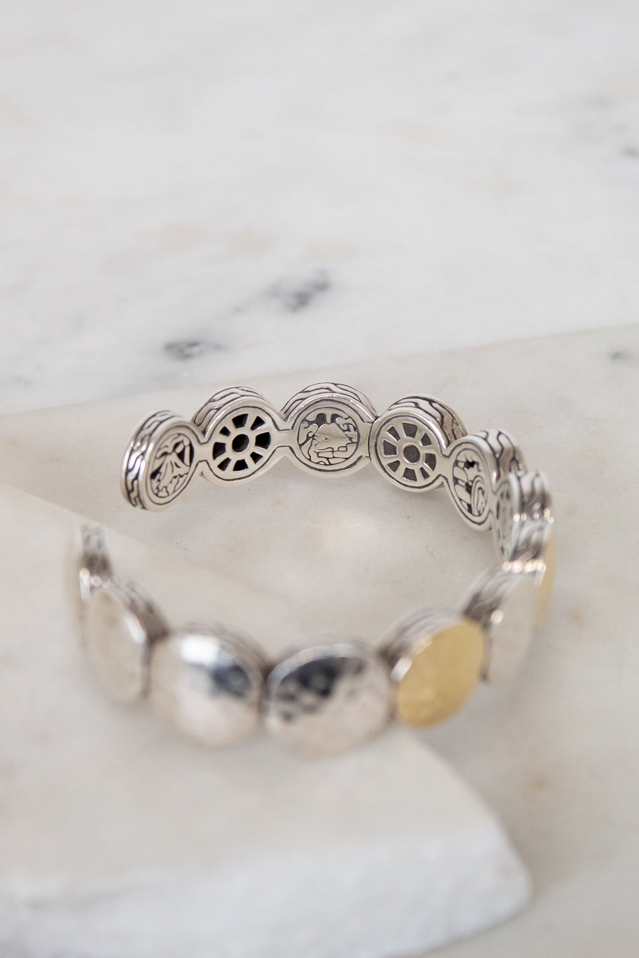 Silver bracelet with decorative elements on a marble surface