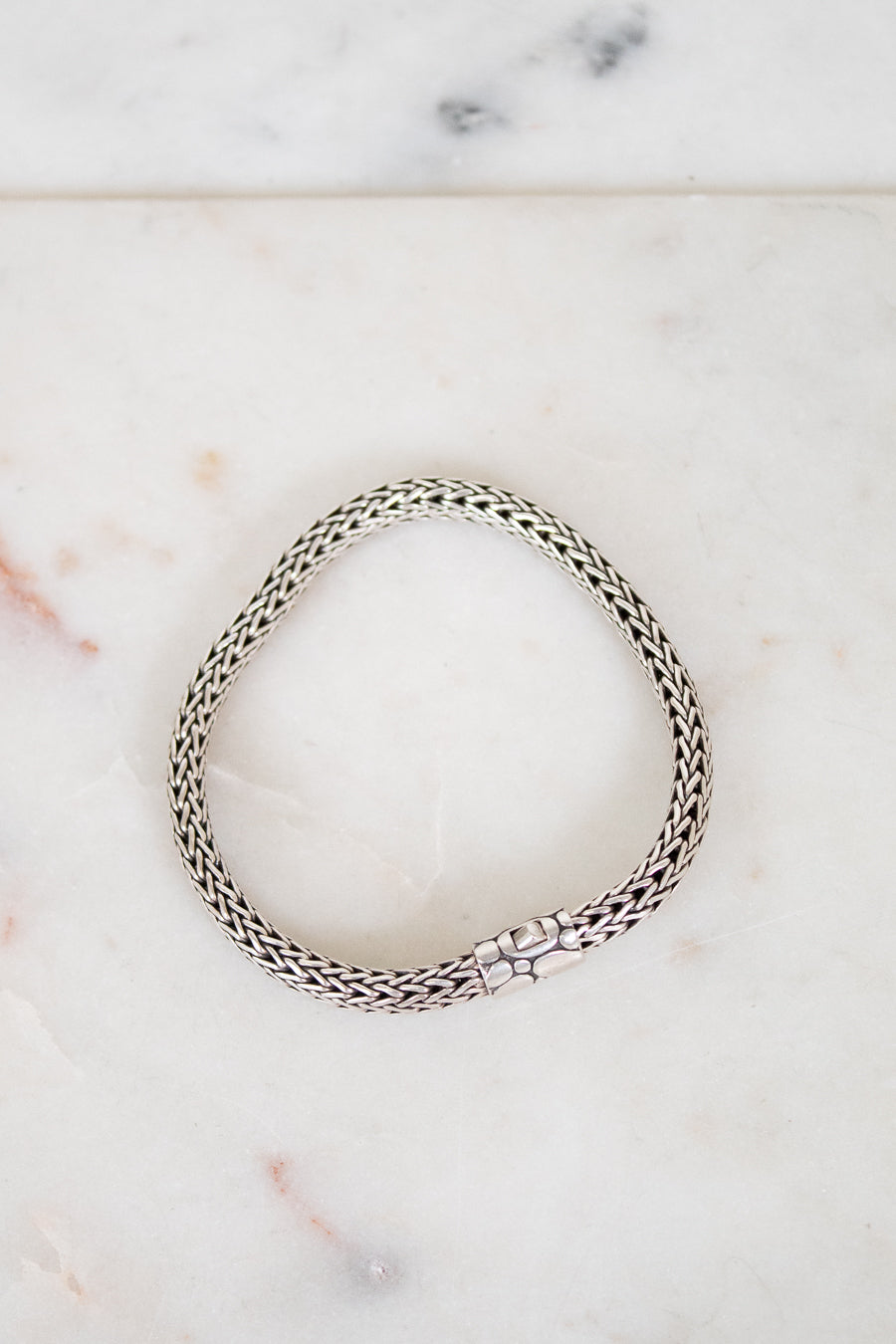 Silver bracelet on a marble surface