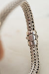 Close-up of a silver bracelet with a blurred background