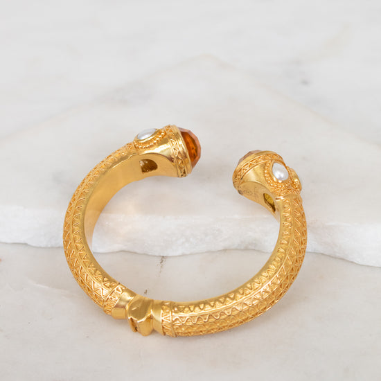 Gold hinge  bracelet on a marble surface