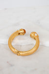 Gold hinge  bracelet on a marble surface