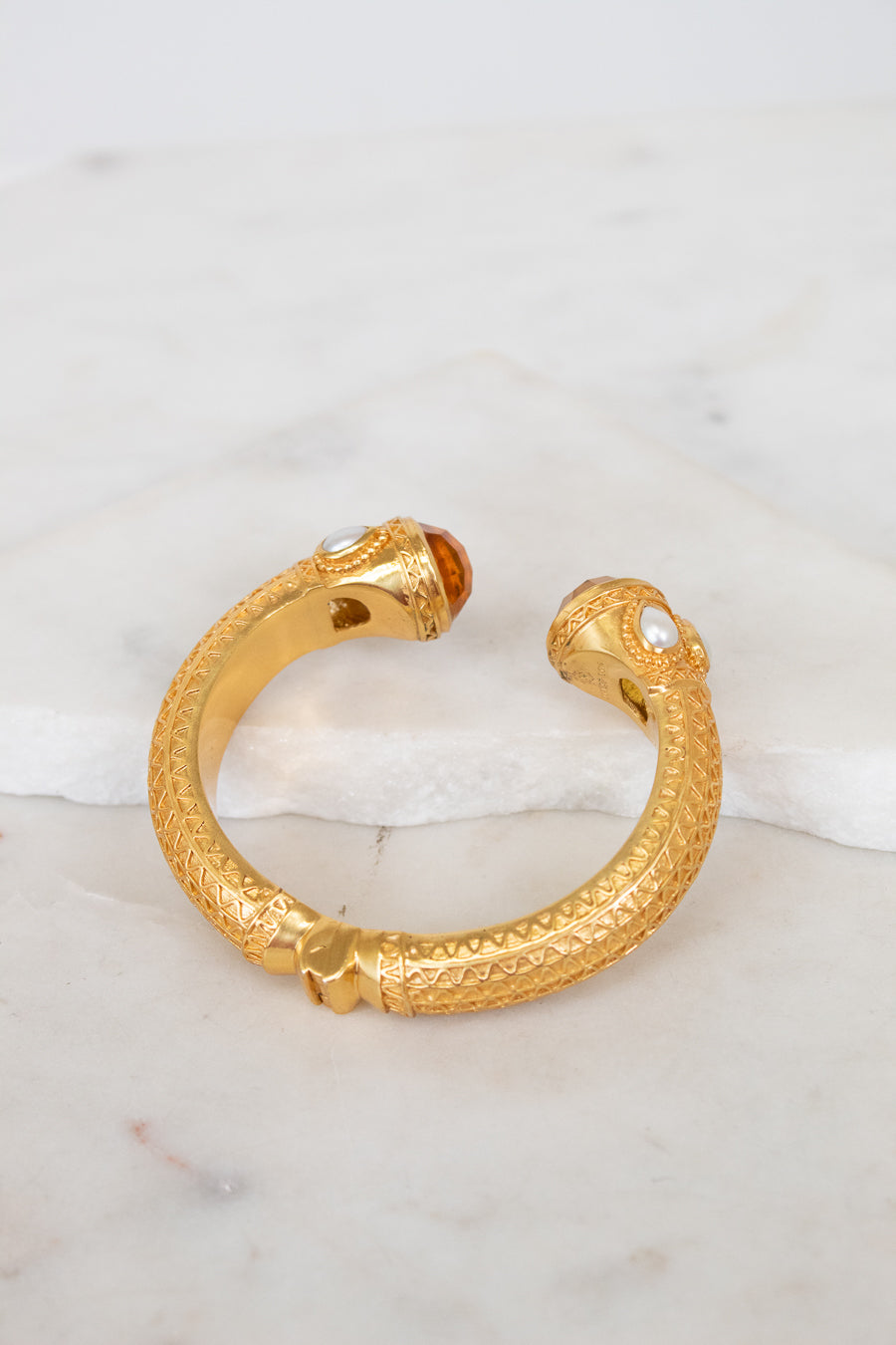 Gold hinge  bracelet on a marble surface