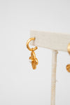 Gold earring on a white stand with a white background