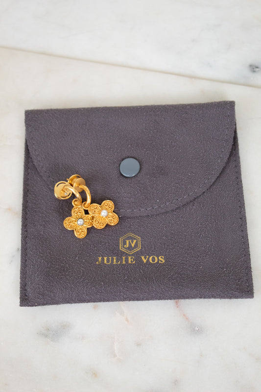 Gold floral earrings on a gray Julie Vos jewelry pouch.
