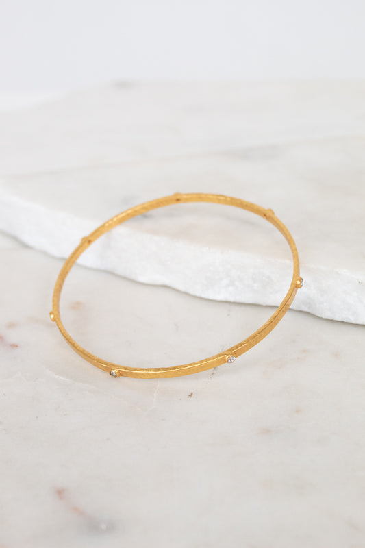 Gold bangle bracelet on a marble surface