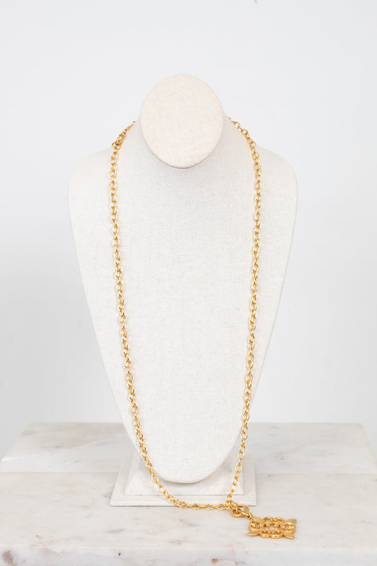 Gold chain necklace on a mannequin bust against a white background