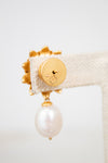 Gold earring with a pearl on a white background