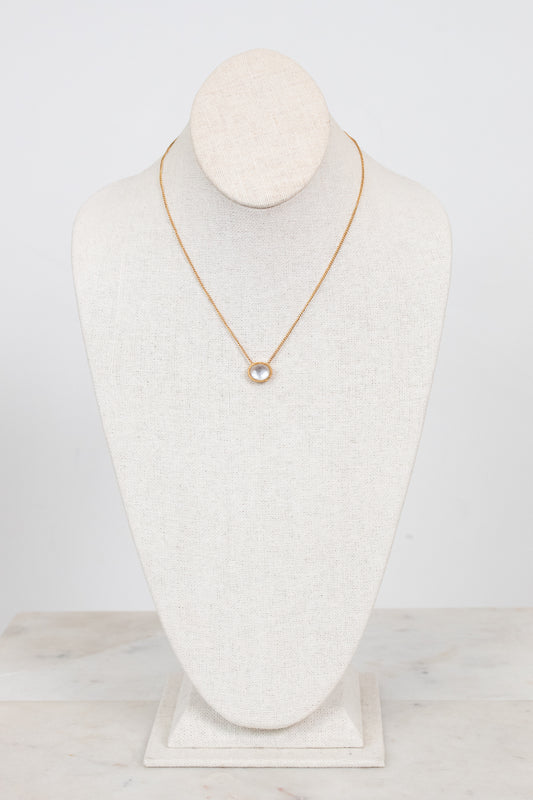 Dainty gold chain necklace with oval center stone detail displayed on a bust against a plain background