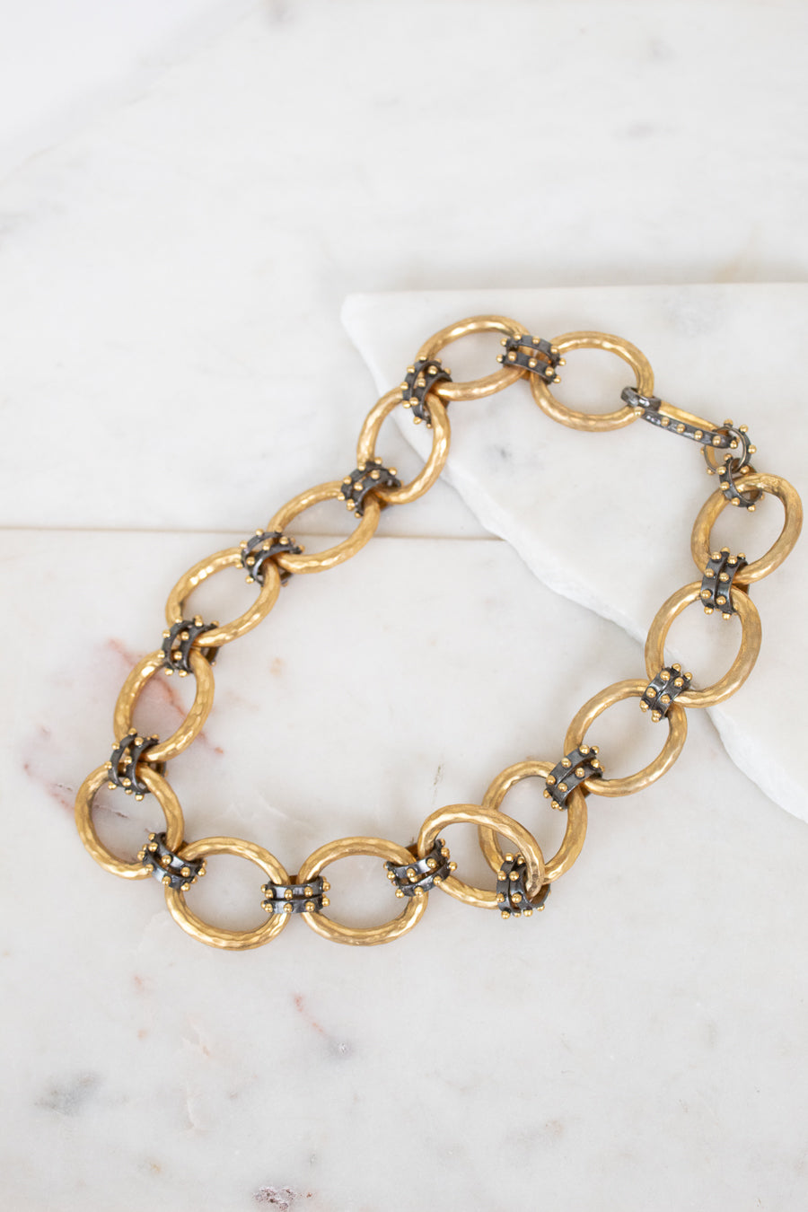 Gold chain necklace on a marble surface