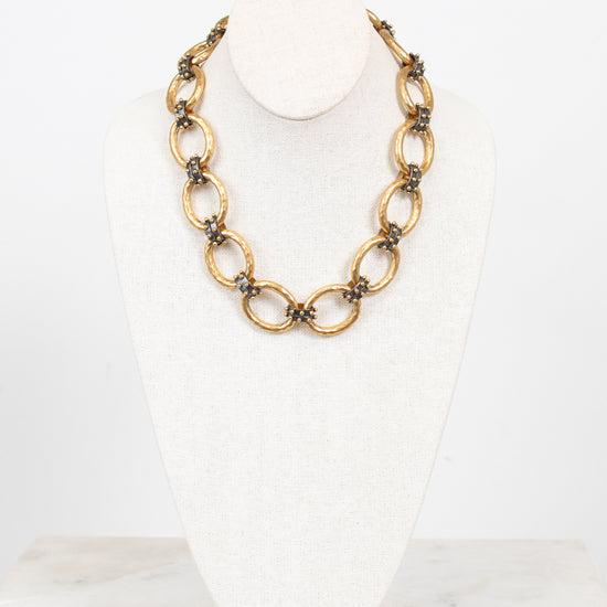 Gold chain necklace on a white bust with a white background
